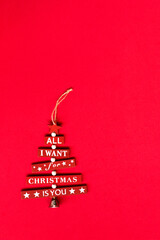 Christmas wood red tree decoration in red background with sentence, stars and bell - All I want for Christmas is you