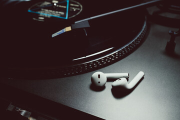 A rather cold image of a record player and some air pods