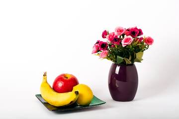 Still life of fruits on a white background, banana, apple, lemon. Side view with copy space for your text. Studio shot