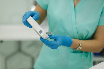 Cosmetologist hold cosmetic product in hand. Attractive medical worker