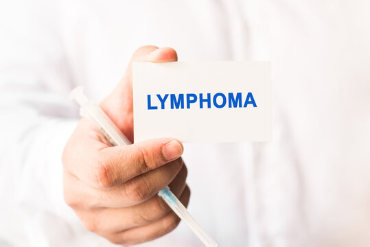 Word lymphoma on a white background with a syringe in hand. Medicine concept