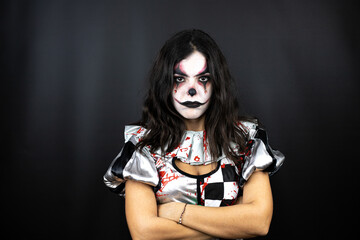 Fototapeta na wymiar woman in a halloween clown costume over isolated black background thinking looking tired and bored with crossed arms