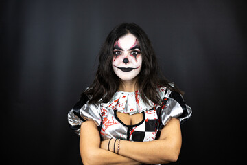 woman in a halloween clown costume over isolated black background with crossed arms looking at the camera smiling