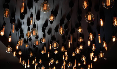 Retro Edison lamp on a black background of the ceiling. Concept idea