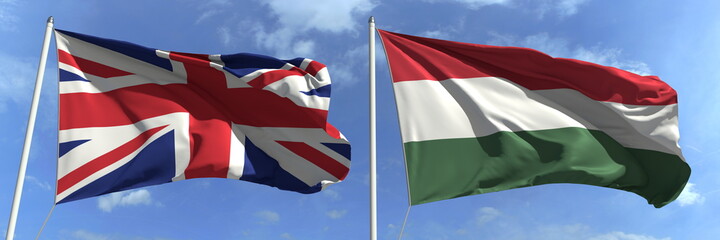 Waving flags of Great Britain and Hungary on flagpoles, 3d rendering