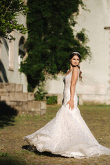 Young female model in wedding dress outdoors. Fashion photo of bride