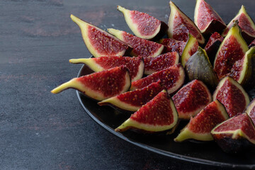 Split figs on a black plate.