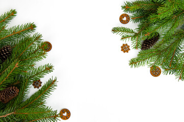 Christmas branches of natural spruce with decorations and cones on a white background close-up.