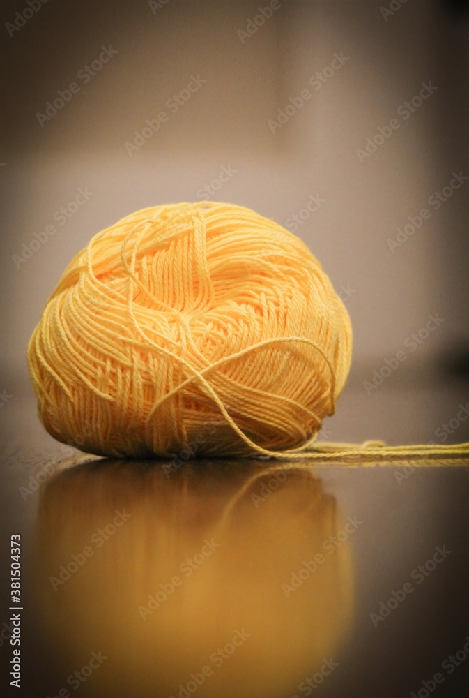 Wall mural ball of yellow yarn on hardwood floor