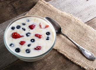 milk with strawberries and blueberries and sesame seeds on a wooden background. healthy food concept.