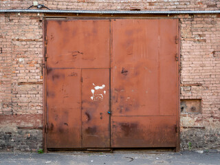 Rusty gate in an old brick warehouse. Old building. Texture, background