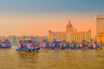 Obraz premium Beautiful Gateway of India near Taj Palace hotel on the Mumbai harbour with many jetties on Arabian sea