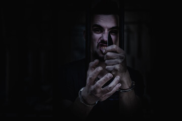 Portrait of aggressive handcuffed man imprisoned for crime, punished for serious villainy. Arrest, gangster, pain concept.