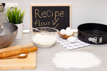 making dough for bread or homemade baked goods. ingredients on the table. recipe board