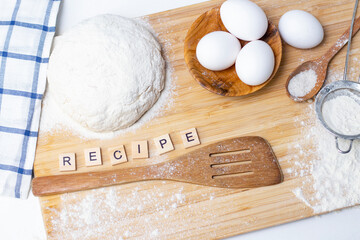 making dough for bread or homemade baked goods. ingredients on a wooden table. inscription: recipe