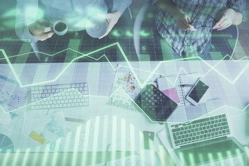 Double exposure of man and woman working together and financial chart hologram drawing. market analysis concept. Computer background. Top View.