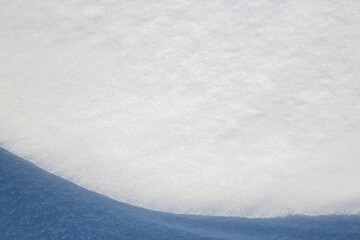 Obraz premium Beautiful winter background with snowy ground. Natural snow texture. Wind sculpted patterns on snow surface. Closeup top view with copy space.