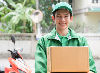 The deliveryman in a green hat, green uniform, a cardboard box mask, smiling brightly.