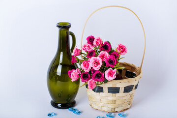 Floral composition with bouquet in basket and glass carafe on white background. Side view with copy...