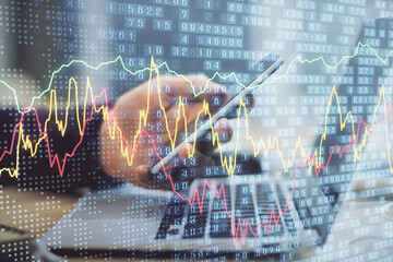 Obraz premium Double exposure of man's hands holding and using a phone and financial graph drawing. Analysis concept.