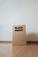 Cardboard box with black friday order written on the box placed on the floor in an empty room with a neutral background. delivery concept. economy concept. black friday concept. shopping concept. 