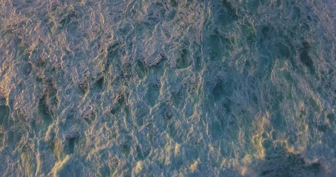 Overhead aerial, ocean waves at sunset in Hawaii