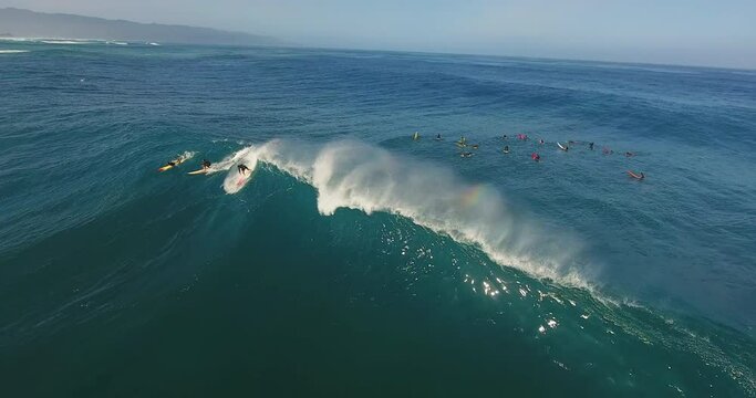 Three surfers catch large wave in Hawaii, aerial
