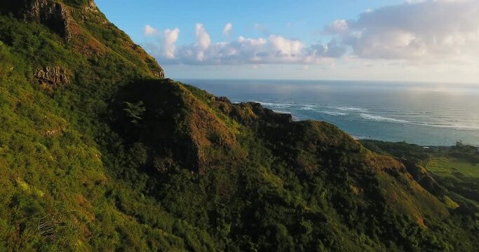 Tilt down aerial, sunset over coastal mountains in Hawaii