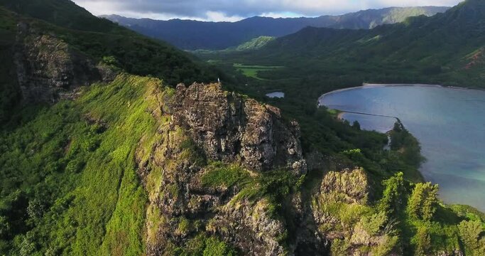 Person hikes along mountain ridge in Ho'omaluhia botanical garden, wide aerial