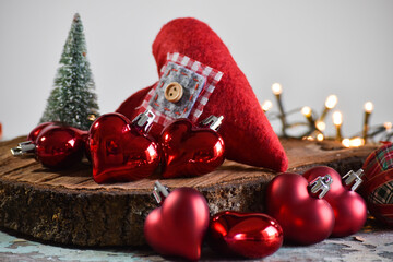 Christmas decoration: handmade hearts of fabric and knitting, stars, Christmas tree and light on the rustic table with gray background.