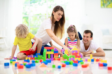 Kids play with toy blocks. Family at home.