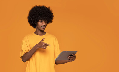 Afro Man pointing on Tablet Screen .