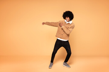 Fototapeta na wymiar Afro happy man dancing in studio.