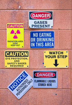 Lot of caution / radiation signs  on block wall.