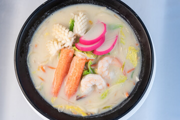Overhead view of large bowl of Chanpon full of squid, crab, and shrimp with delicate presentation for serving.