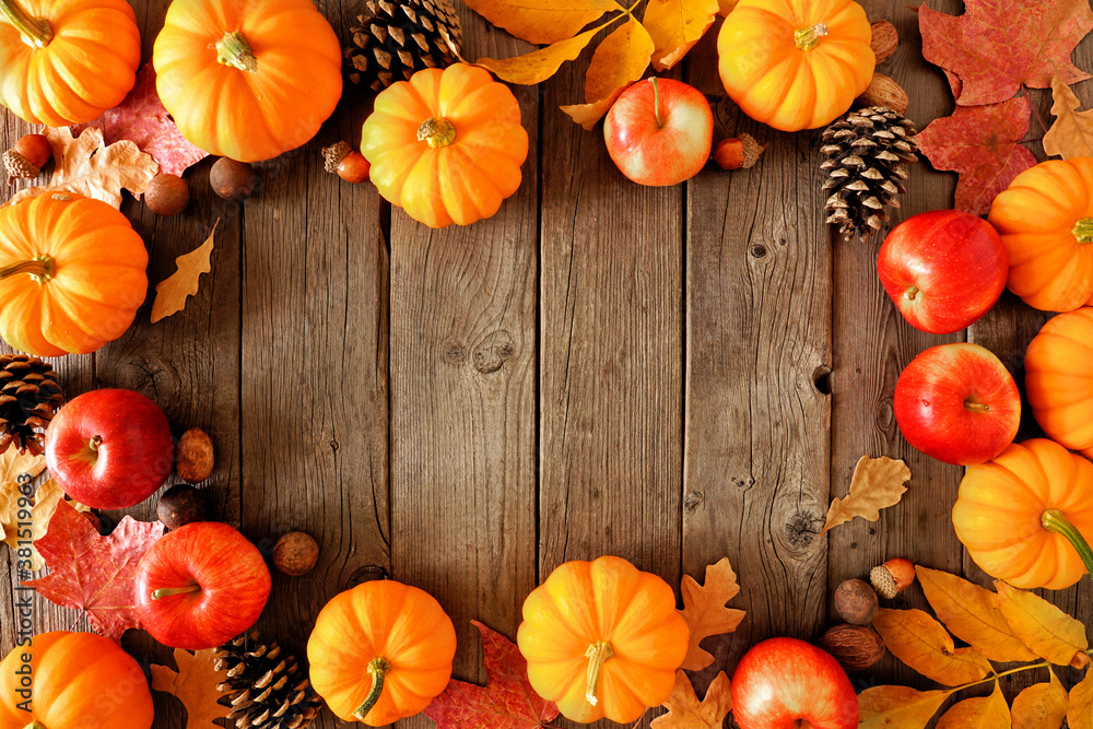 Poster Autumn frame with pumpkins, leaves and apples. Overhead view on a rustic dark wood background with copy space.