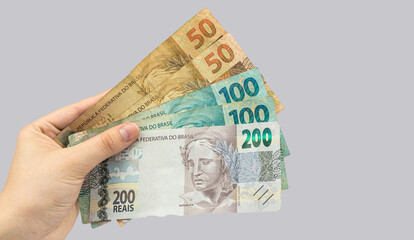 new note of two hundred Brazilian reais with some parts in focus and a blurred part on top of the flag of Brazil