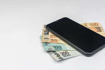 new note of two hundred Brazilian reais with some parts in focus and a blurred part on top of the flag of Brazil