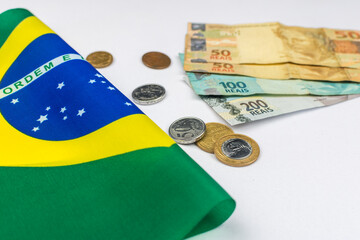 new note of two hundred Brazilian reais with some parts in focus and a blurred part on top of the flag of Brazil