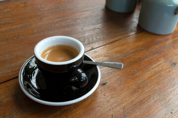 Obraz premium Black coffee in a cup on a wooden table