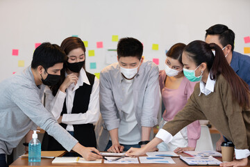 New normal group of Business man and woman wearing face mask meeting and working together for discussion and brainstroming to get ideas or marketing solution with social distance due virus pandemic