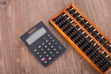 A black calculator and an abacus