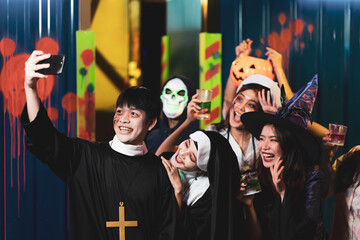Obraz premium Group of asian friends rest in a nightclub with colored cocktails Wearing Halloween Costumes at Party in Nightclub by doing Scary faces. Celebration of Halloween