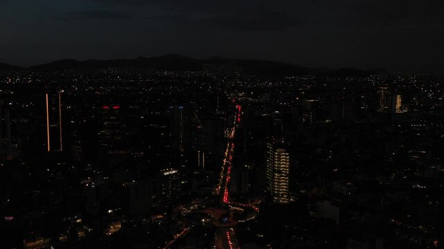Vista a&eacute;rea nocturna del tr&aacute;fico vehicular sobre Av. Insurgentes sur a la altura de la Glorieta de Insurgentes. El drone volando al frente