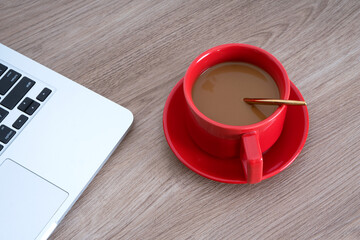 Looking down shot a cup of coffee and a laptop on the table
