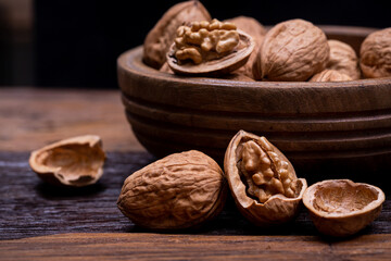 still life with Walnut kernels and whole walnuts on rustic old wooden table.