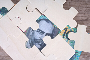Australian dollar banknote revealed in a jigsaw puzzle on the table