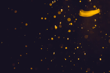 Fototapeta na wymiar Dark Abstract Gold bokeh sparkle on black