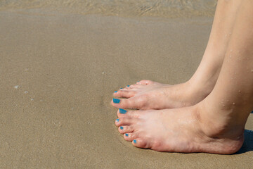 Fototapeta na wymiar The woman's foot nailed the sand