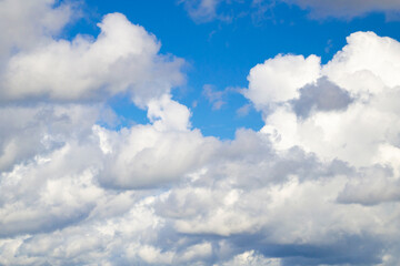 Naklejka na ściany i meble Natural background. Blue sky with white clouds. Many white clouds on a sunny day.